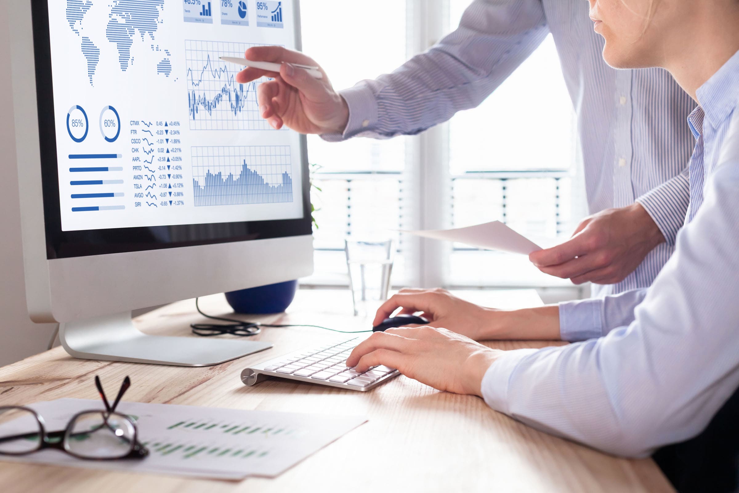 Dos personas que analizan las gráficas generadas por los fondos indexados
