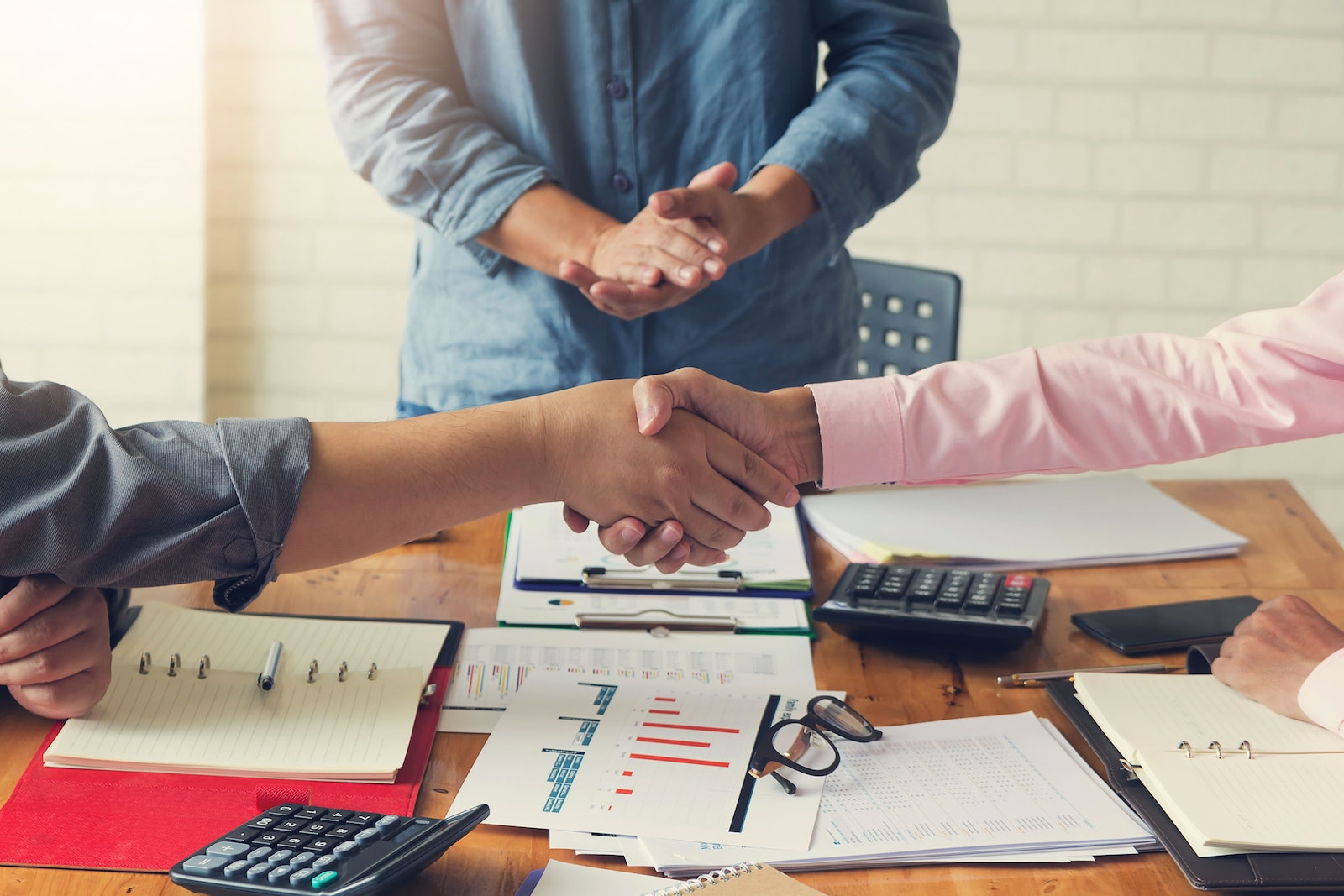 Empresarios se dan la mano en señal de acuerdo para franquiciar sus negocios