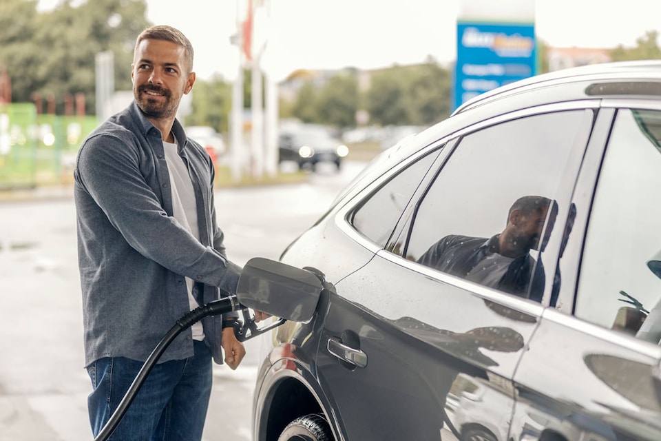 Hombre repostando GLP mientras consulta cuánto cuesta