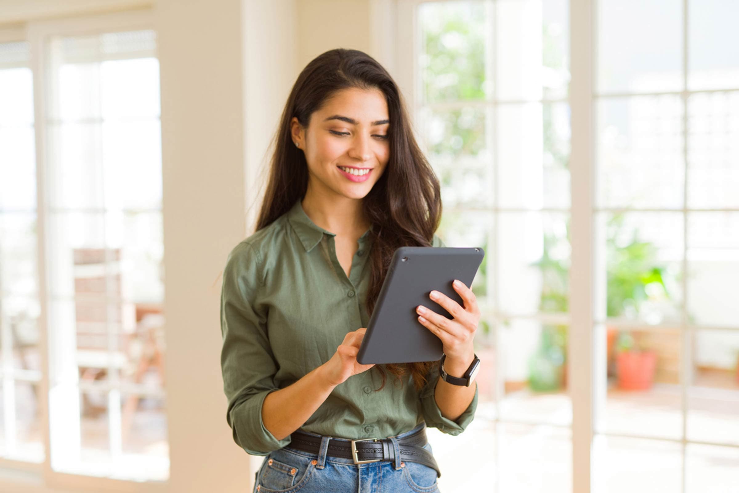 Mujer consultando en la tablet el valor fiscal de su vivienda