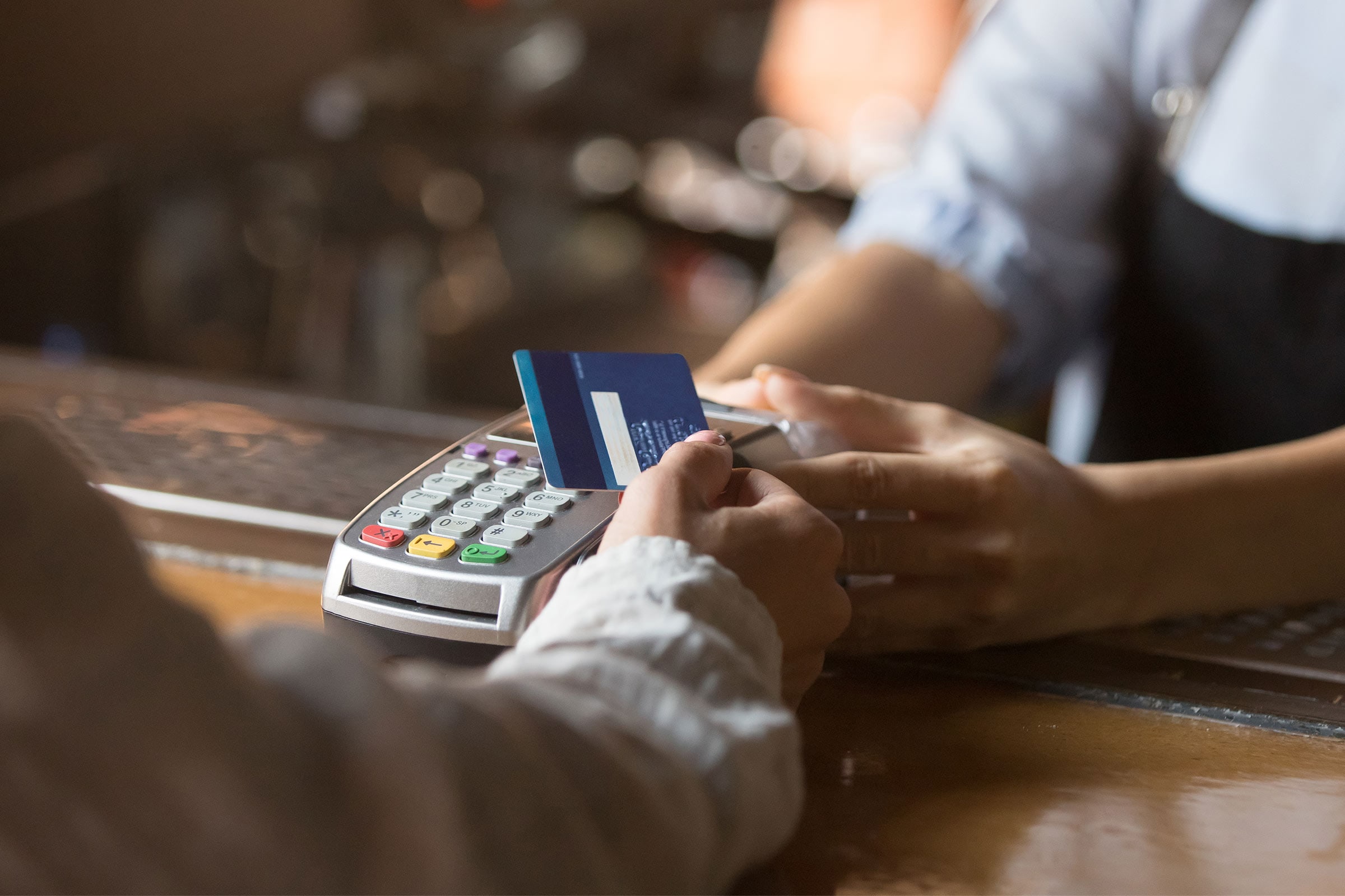 Persona pagant amb la seva targeta contacless en un establiment