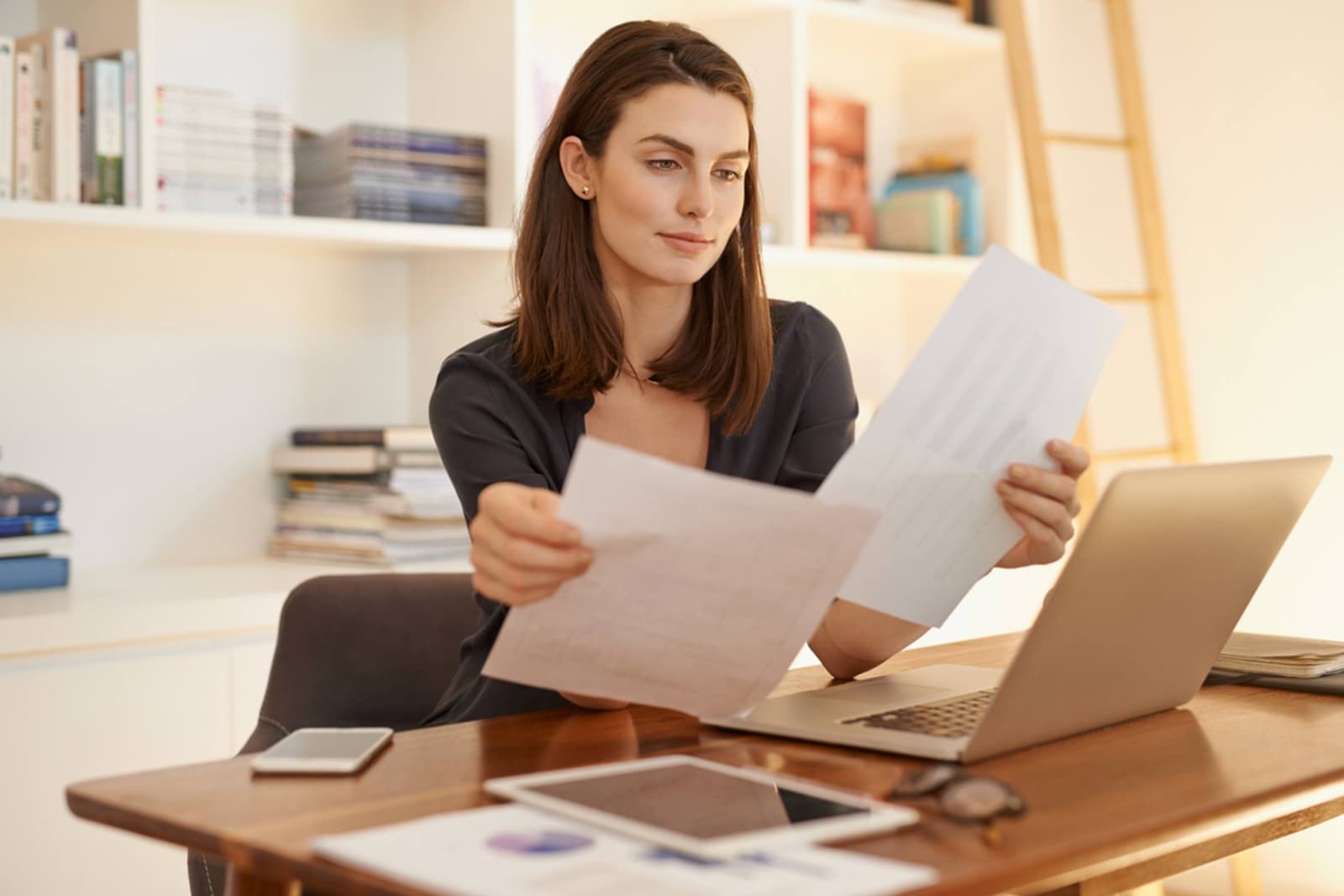 Mujer revisando el documento del recibo de autónomo, en el que se puede consultar la cuenta en la que este se ha domiciliado (en caso de querer cambiarlo)