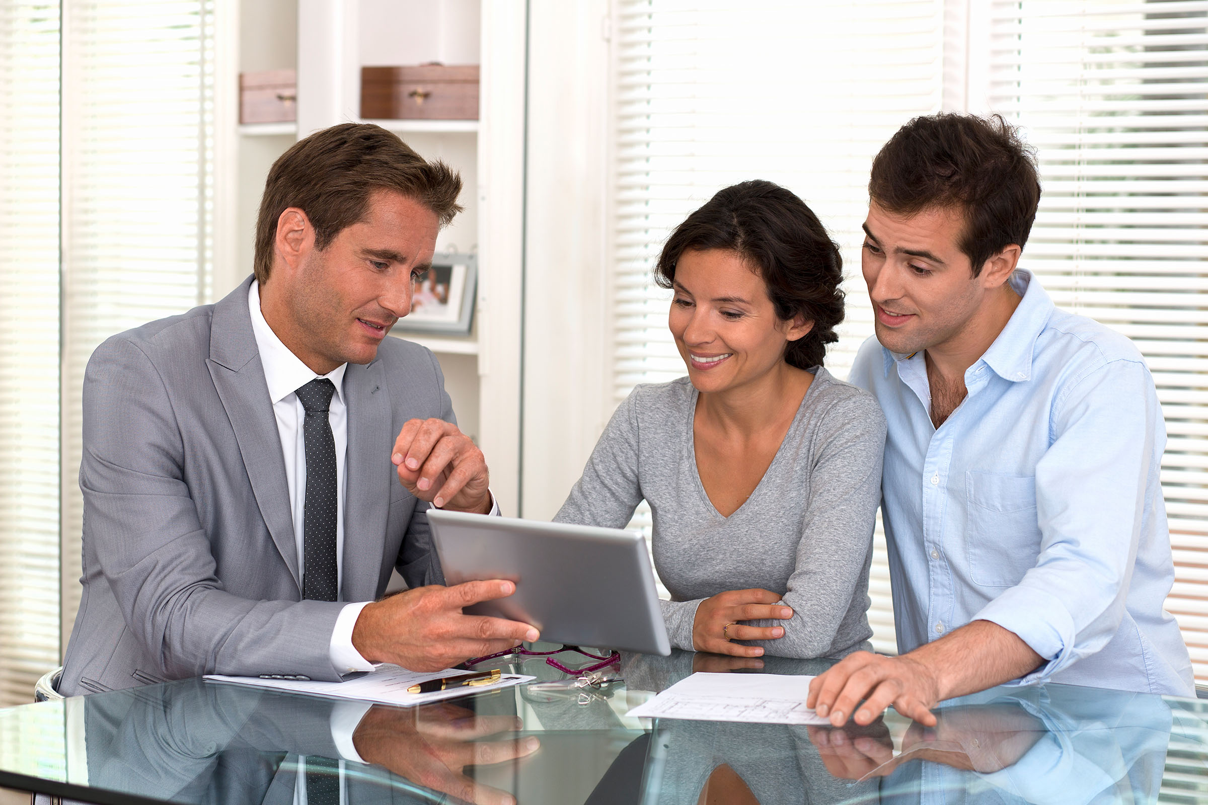 Asesor indicando a clientes las posibles formas de invertir su dinero