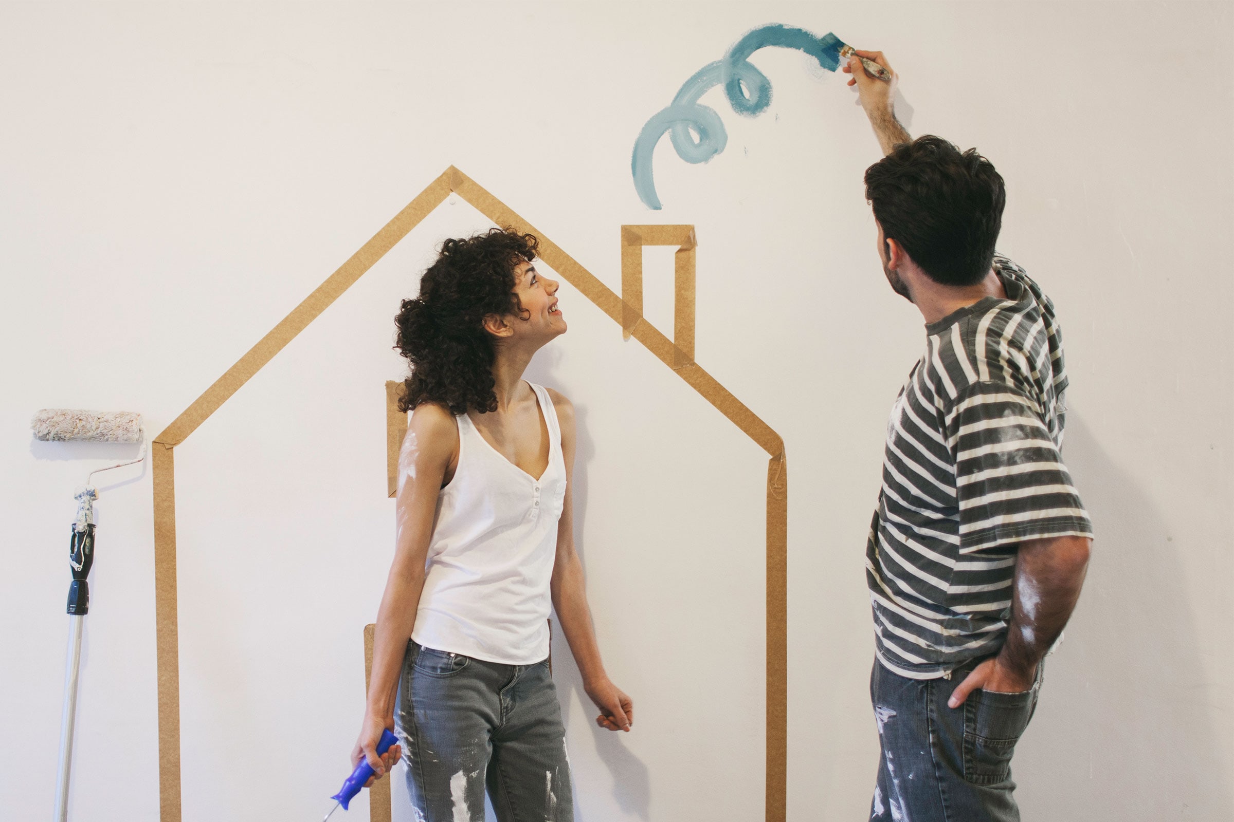Pareja pintando su nuevo hogar