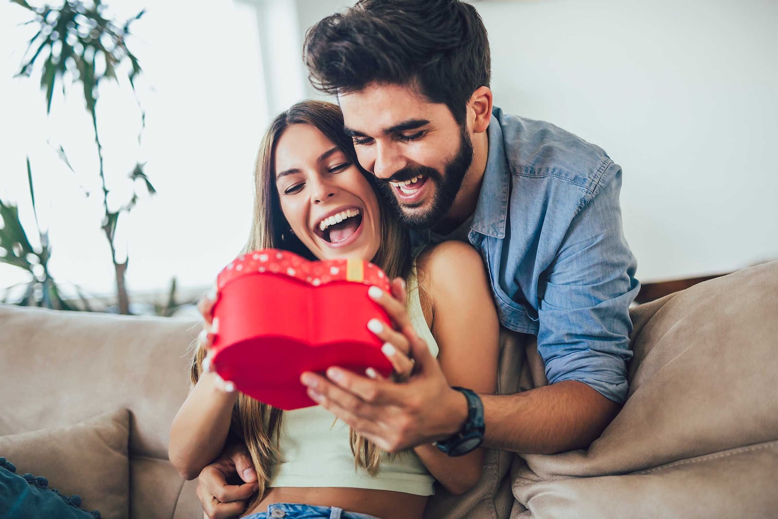 Pareja en su casa con una caja de bombones