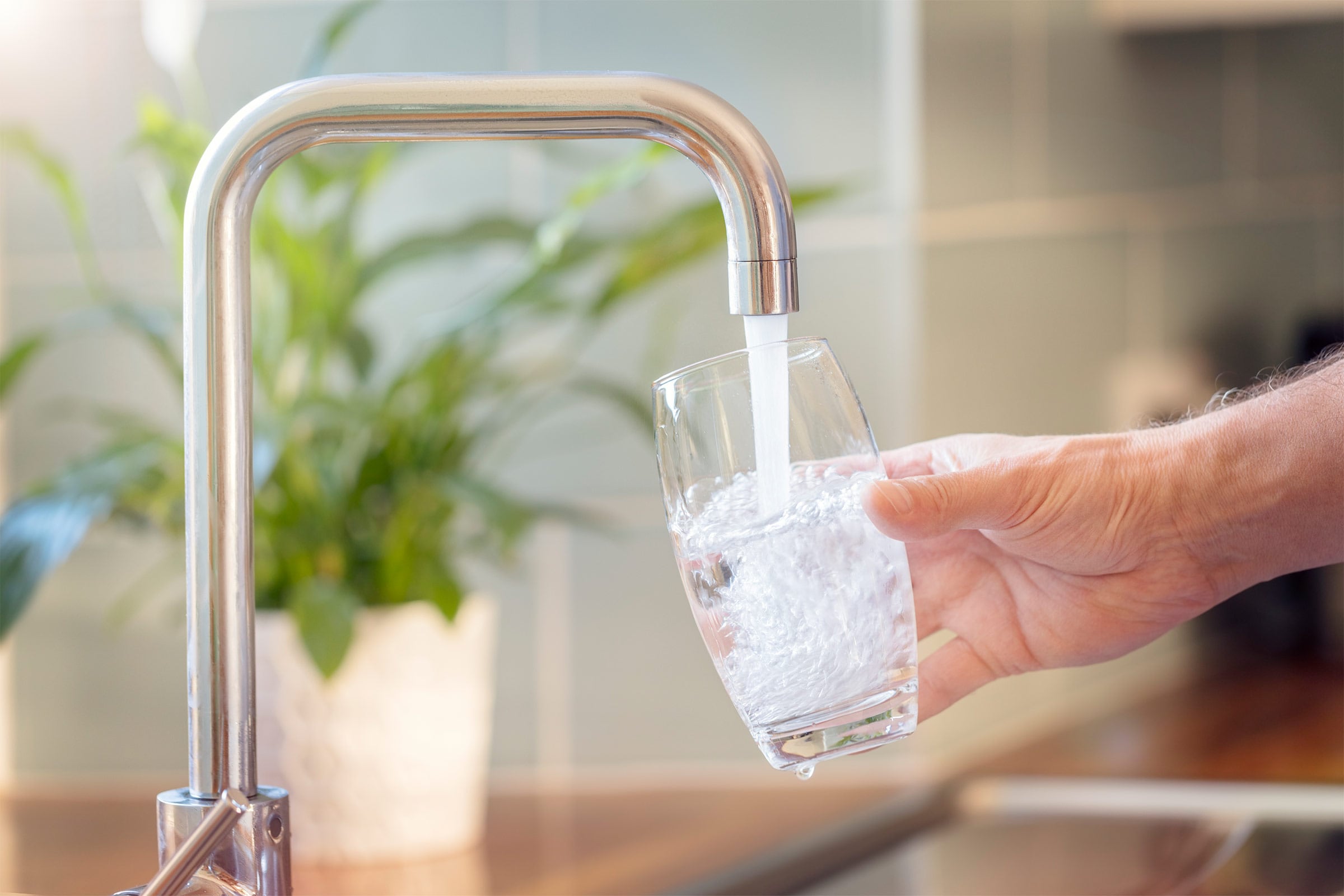 Persona cogiendo un vaso de agua del grifo