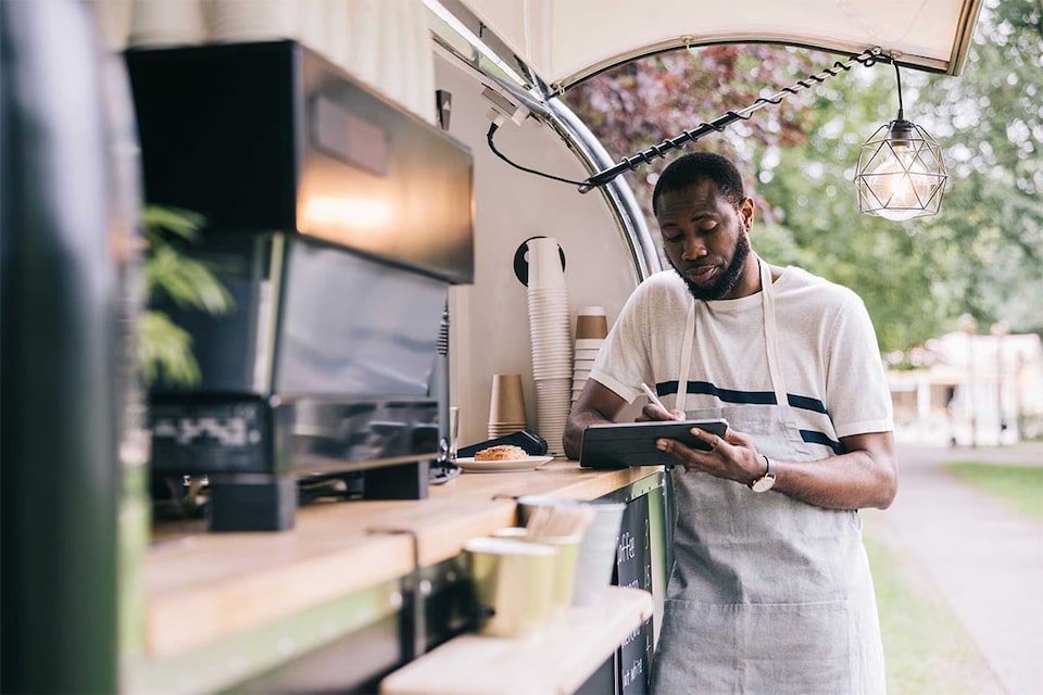 waiter looks at BBVA's financing options on his tablet as a business account customer