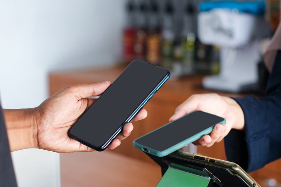 Woman explains to customer how the mobile payment POS terminal works