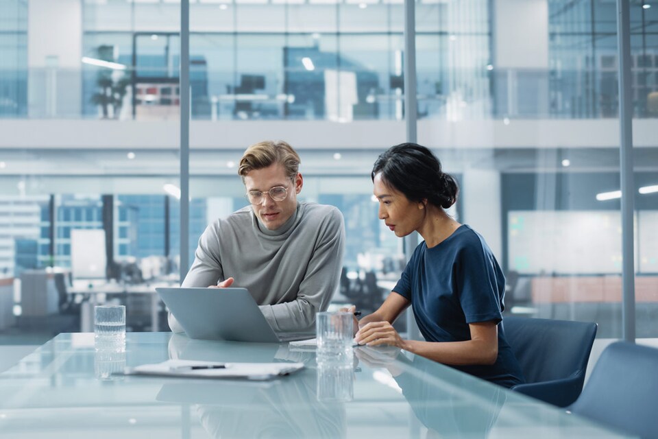Dos personas revisando la forma de organizar las facturas de la empresa