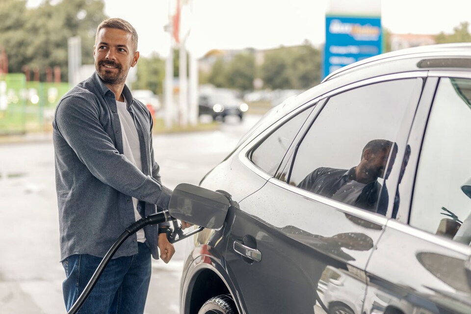 Hombre repostando GLP mientras consulta cuánto cuesta