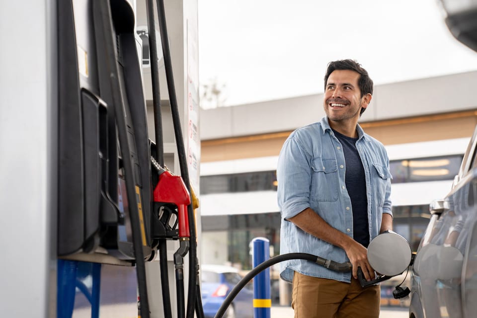 Hombre repostando su vehículo GLP en una gasolinera