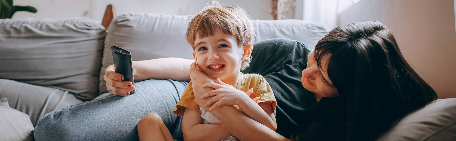 A girl and a boy marking their height on the living room wall