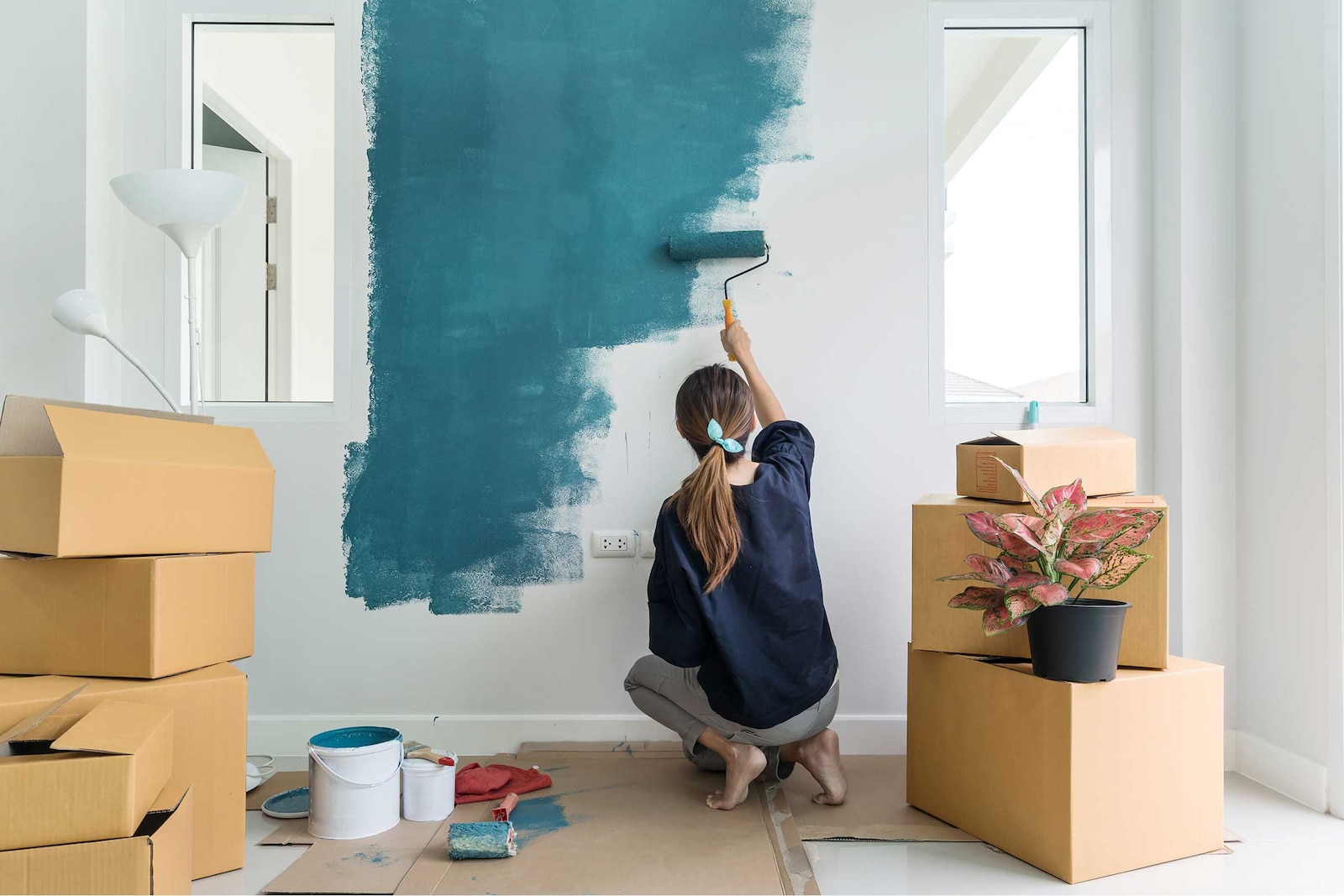 Woman painting her living room blue