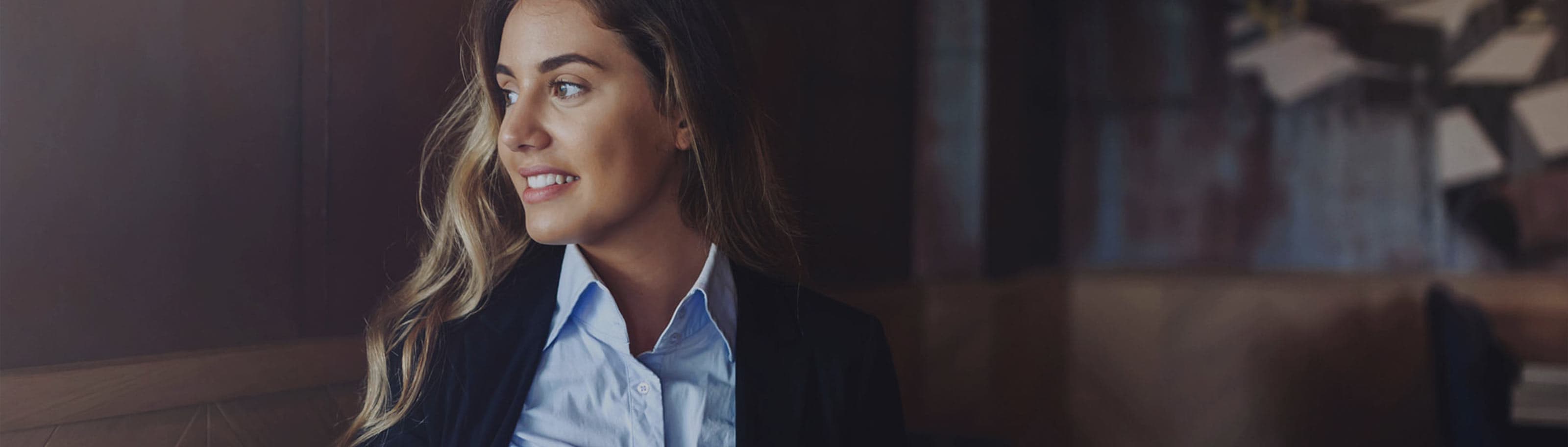 Young, professionally dressed woman sitting in a café