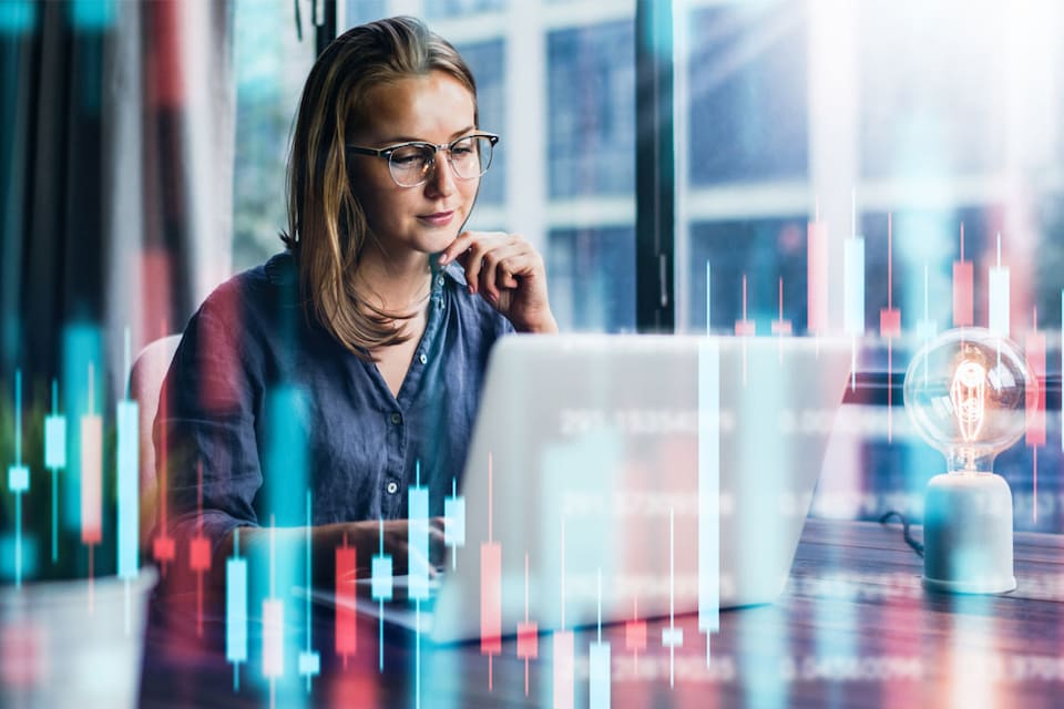 Mujer frente al ordenador, realizando tareas de trading